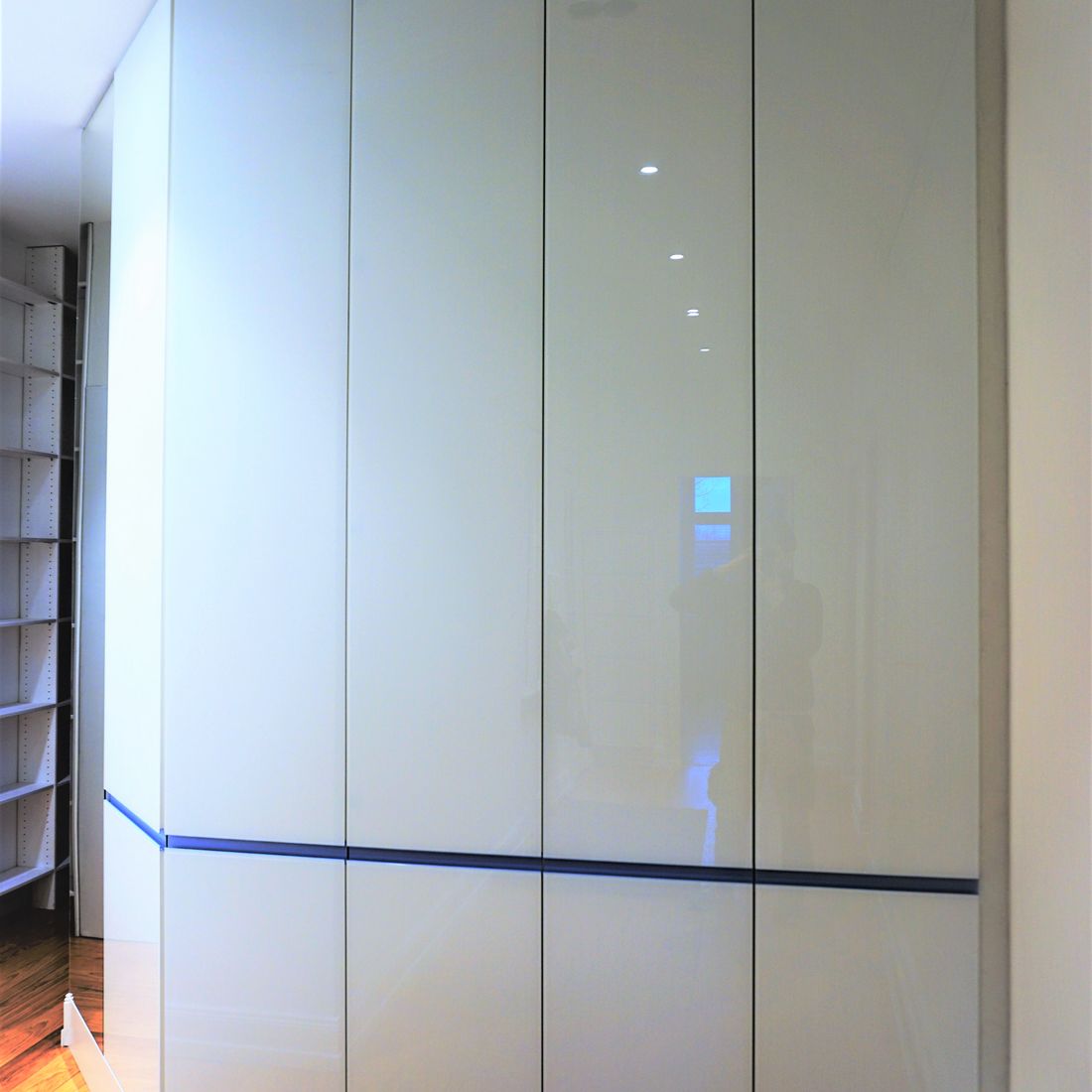 raumhohe Garderobe mit lackierter Glasfront
